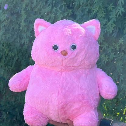 Peluche de gatito rosa con orejas puntiagudas y detalles blancos.