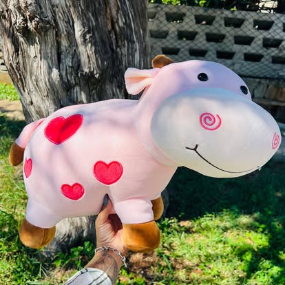 Peluche de hipopótamo rosa con corazones rojos.