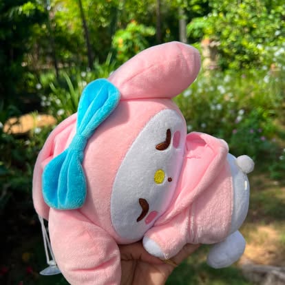 Peluche rosa de My Melody, con orejas largas y un lazo azul.