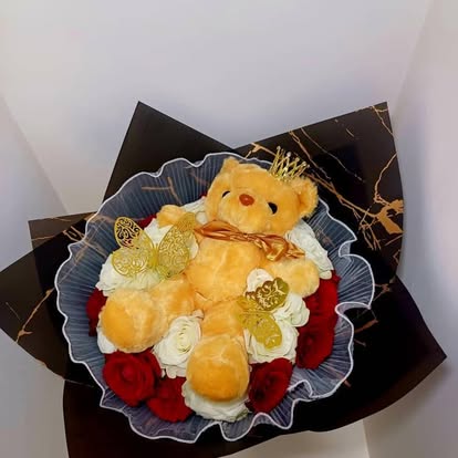Un peluche rodeado de flores