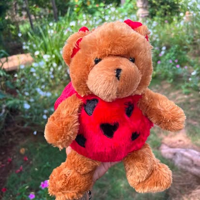 Osito marrón con un suéter rojo decorado con corazones.
