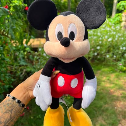 Peluche de Mickey con pantalón rojo, guantes blancos y zapatos amarillos.