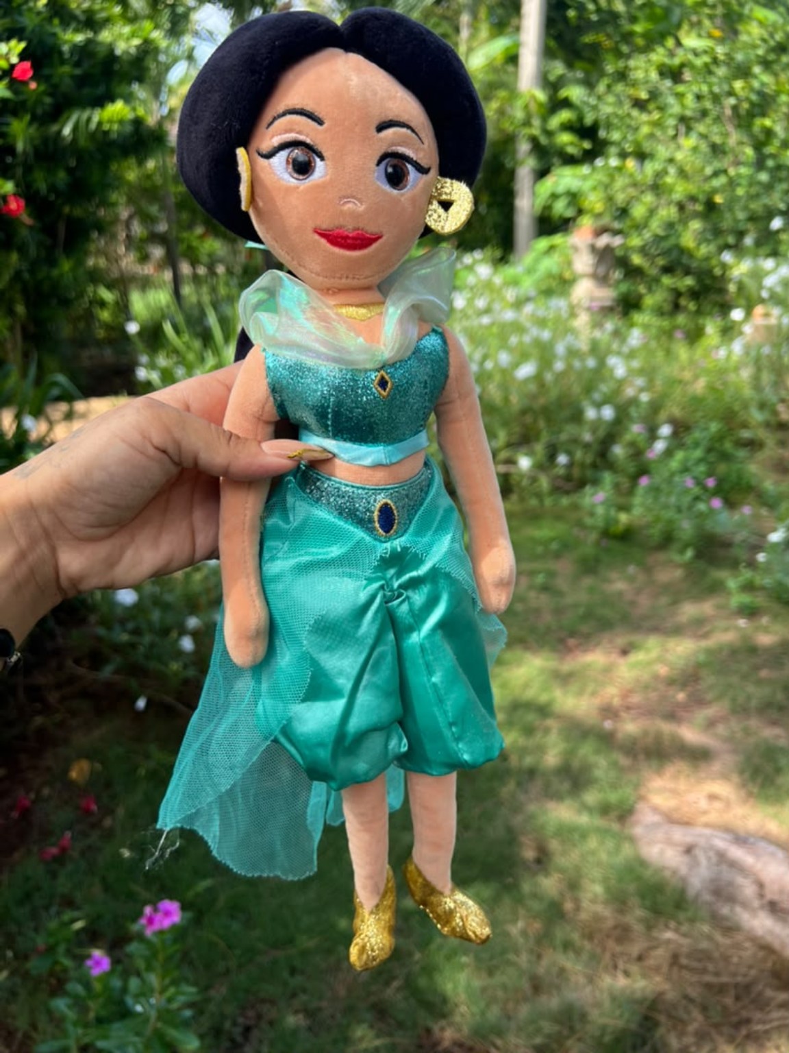 Muñeca de peluche de princesa con cabello oscuro y vestido turquesa.