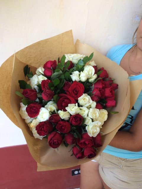Rosas en tonos rojos y claros, con follaje y envoltura kraft.