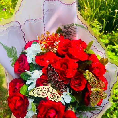 Ramo rojo con flores claras, mariposas y una corona decorativa.