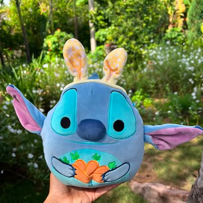 Peluche de Stitch con orejas de conejo y detalles de zanahorias.