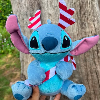 Peluche de Stitch con detalles de bastones de caramelo rojos y blancos.