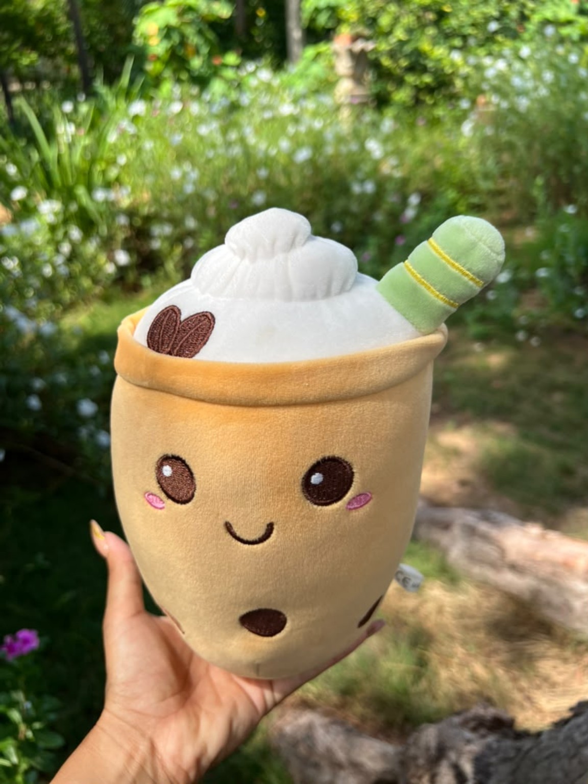 Peluche con forma de vaso de bebida, rostro sonriente y pajita verde.